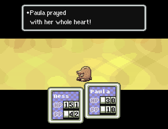 Paula prays during a battle with a Mole Playing Rough.